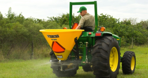 a man on a tractor spreading seed