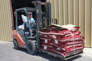 man moving seed bags with forklift